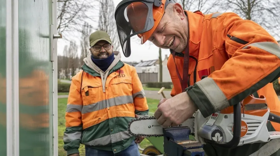 Medewerker maakt de kettingzaag schoon